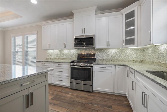 kitchen with light stone counters, dark hardwood / wood-style flooring, white cabinets, and stainless steel appliances