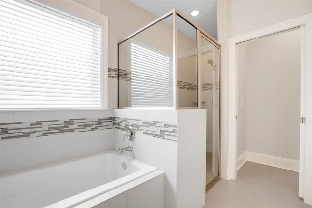 bathroom featuring tile patterned flooring, shower with separate bathtub, and a wealth of natural light