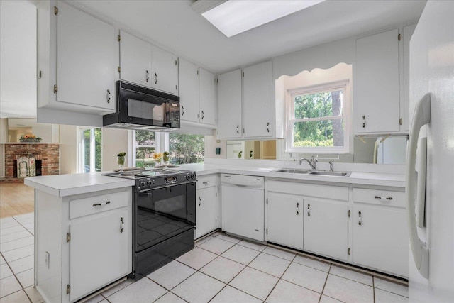 kitchen with a sink, light tile patterned floors, black appliances, and light countertops
