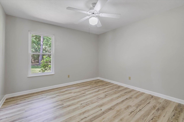 empty room with a ceiling fan, baseboards, and wood finished floors