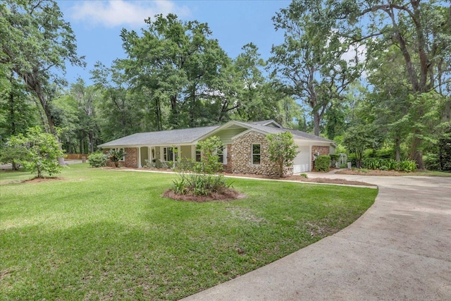 view of front facade featuring an attached garage, a front yard, driveway, and stone siding
