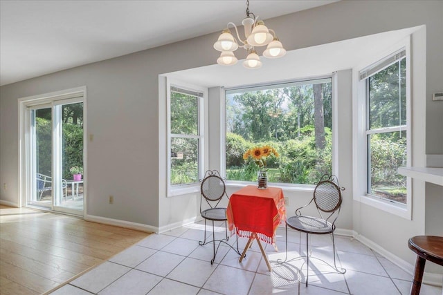 dining room featuring baseboards, light tile patterned flooring, and a notable chandelier