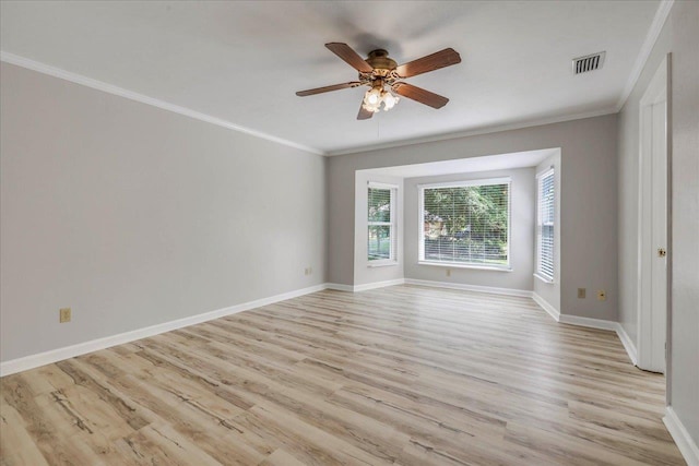spare room with crown molding, a ceiling fan, light wood finished floors, and baseboards