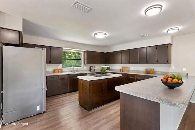 16552 198th Trace, Trace, FL 32071 - kitchen with freestanding refrigerator, dark brown cabinetry, light countertops, and light wood-type flooring