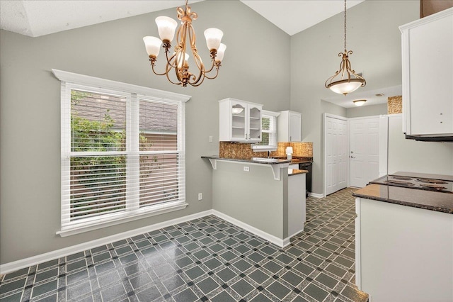 2032 Ascot Way, Tallahassee, FL 32312 - kitchen featuring dark floors, dark countertops, white cabinets, high vaulted ceiling, and a peninsula
