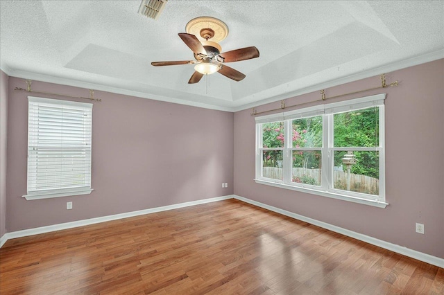 2032 Ascot Way, Tallahassee, FL 32312 - spare room featuring a textured ceiling, a tray ceiling, light wood-style flooring, ceiling fan, and crown molding