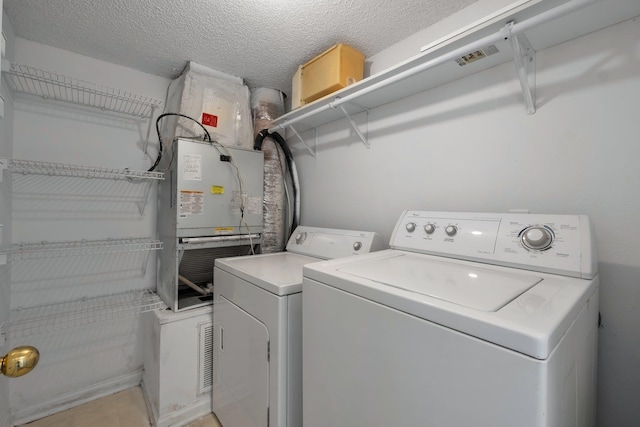 1997 Maymeadow Ln, Tallahassee, FL 32303 - washroom with washer and clothes dryer, heating unit, and a textured ceiling