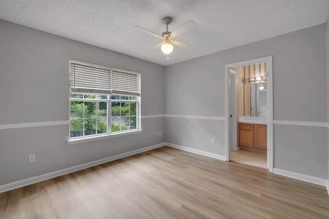 1997 Maymeadow Ln, Tallahassee, FL 32303 - unfurnished bedroom with light wood finished floors, a textured ceiling, and baseboards