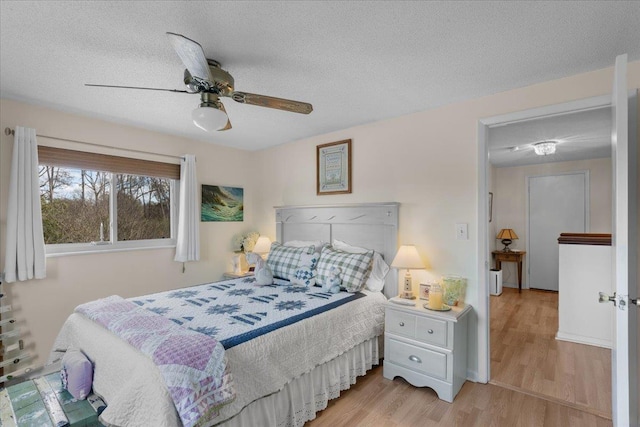 bedroom featuring ceiling fan, a textured ceiling, and light hardwood / wood-style floors