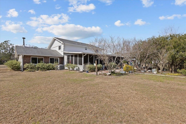 back of house with central AC, a yard, and a sunroom