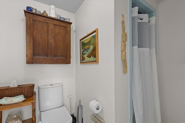 bathroom with curtained shower and toilet