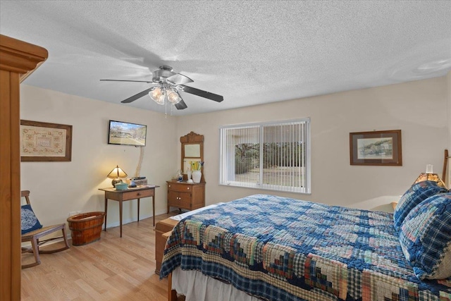 bedroom with a textured ceiling, light hardwood / wood-style floors, and ceiling fan