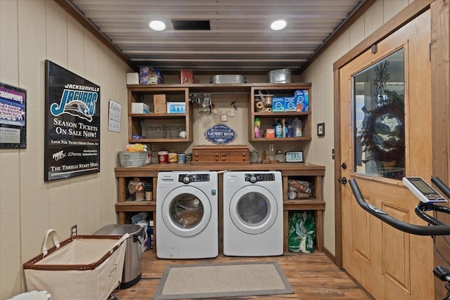 laundry room with hardwood / wood-style floors and washer and dryer