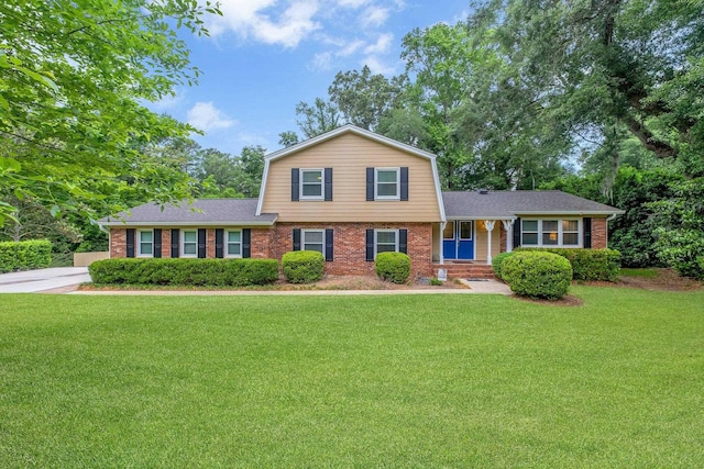 3514 Tullamore Ln, Tallahassee, FL 32309 - view of front of home with brick siding, a gambrel roof, a front yard, and a shingled roof