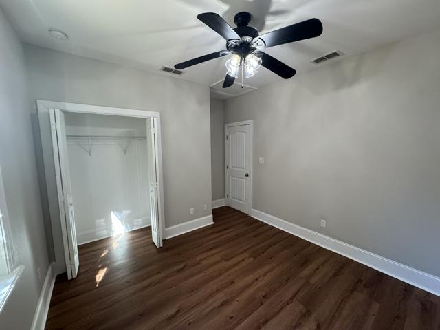 unfurnished bedroom featuring ceiling fan, a closet, and dark hardwood / wood-style floors