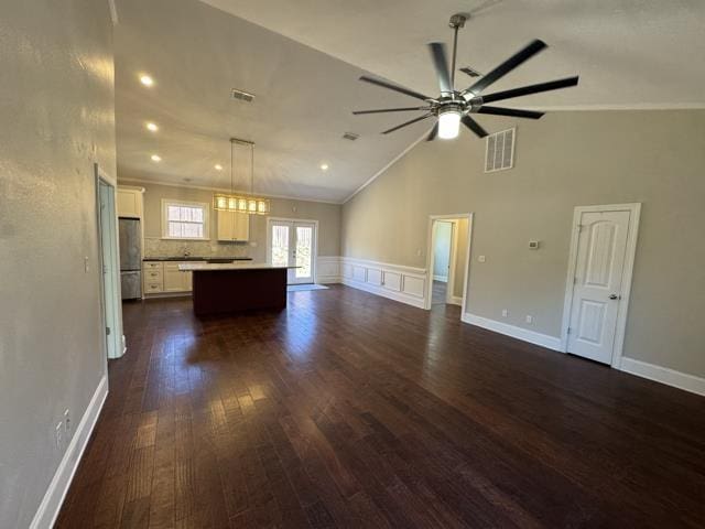 unfurnished living room featuring french doors, crown molding, vaulted ceiling, ceiling fan, and dark hardwood / wood-style floors