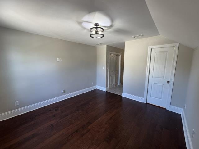 interior space featuring dark hardwood / wood-style flooring and vaulted ceiling