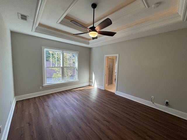 empty room featuring ceiling fan, dark hardwood / wood-style flooring, crown molding, and a tray ceiling