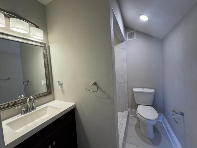 bathroom featuring walk in shower, vanity, and toilet