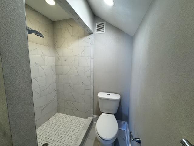 bathroom with tiled shower and toilet