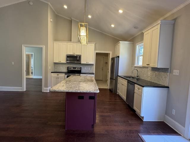 kitchen with sink, ornamental molding, a kitchen island, white cabinetry, and stainless steel appliances