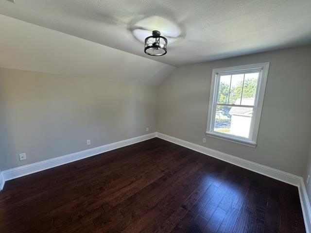 bonus room featuring dark hardwood / wood-style floors and vaulted ceiling