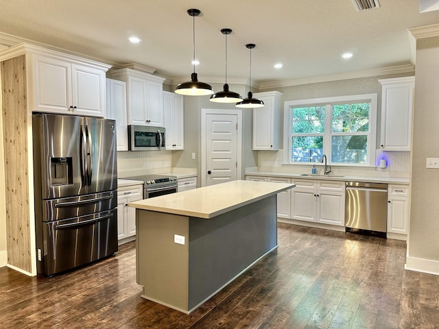 3646 Homestead Rd, Tallahassee, FL 32309 - kitchen with stainless steel appliances, white cabinetry, light countertops, dark wood-style flooring, and ornamental molding