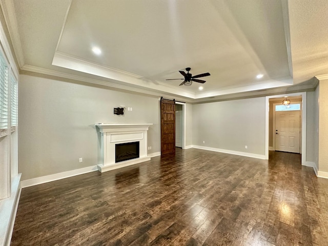 3646 Homestead Rd, Tallahassee, FL 32309 - unfurnished living room with a tray ceiling, dark wood-style flooring, a barn door, a ceiling fan, and crown molding