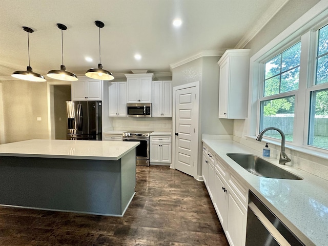 3646 Homestead Rd, Tallahassee, FL 32309 - kitchen featuring stainless steel appliances, a sink, crown molding, white cabinets, and hanging light fixtures