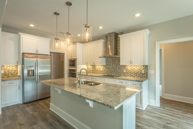 kitchen featuring stainless steel appliances, white cabinets, a sink, and wall chimney exhaust hood