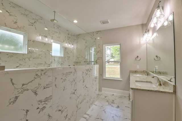 bathroom with marble finish floor, a marble finish shower, visible vents, and a sink