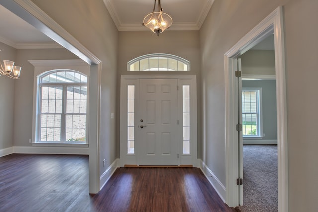 entryway with crown molding, dark wood-style flooring, baseboards, and an inviting chandelier