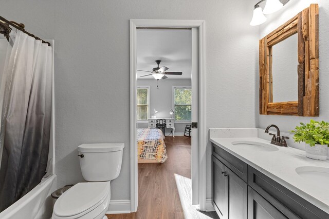 full bathroom featuring wood-type flooring, vanity, shower / tub combo, toilet, and ceiling fan