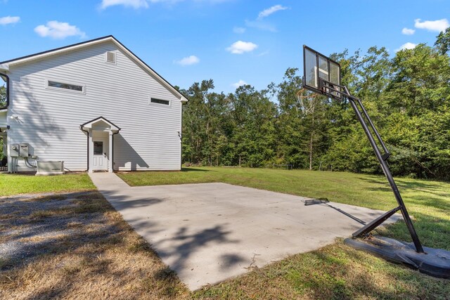 view of sport court with a yard