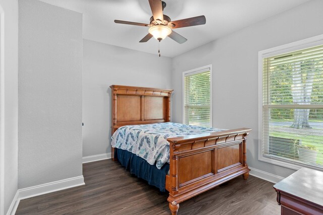 bedroom with dark hardwood / wood-style flooring and ceiling fan