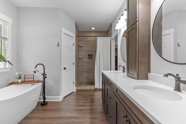 bathroom featuring shower with separate bathtub, wood-type flooring, and vanity