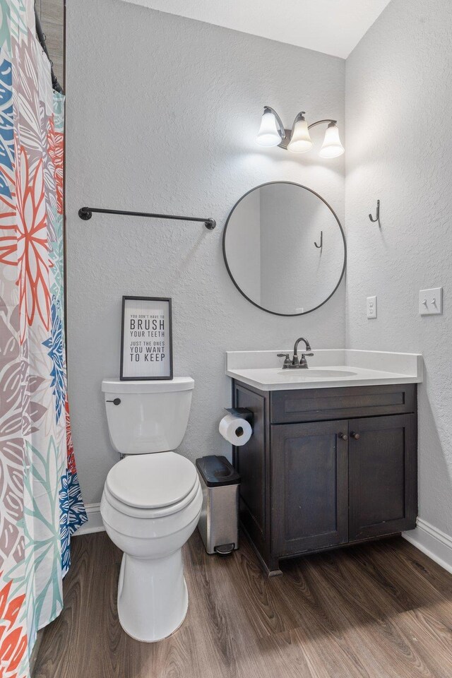 bathroom featuring vanity, hardwood / wood-style flooring, and toilet