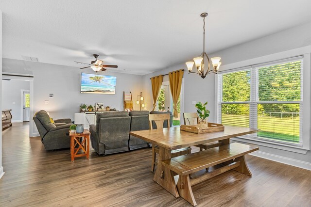 dining room featuring ceiling fan with notable chandelier and hardwood / wood-style flooring