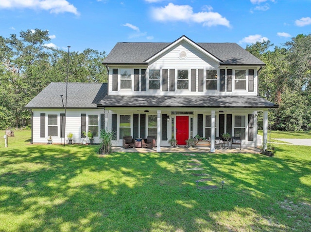 colonial-style house featuring a front yard and a patio area