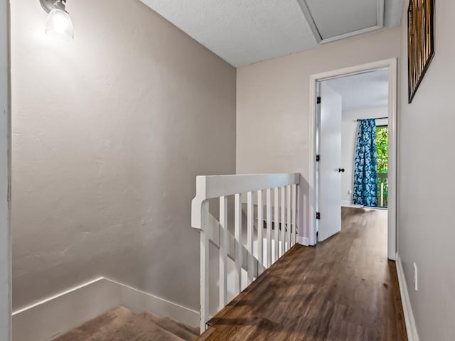 hall with hardwood / wood-style floors and a textured ceiling