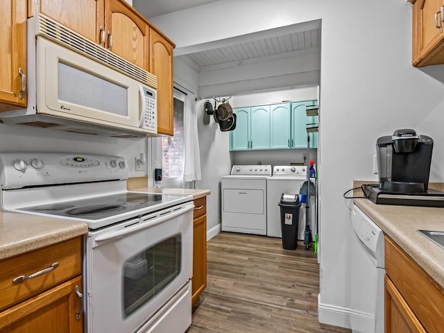 kitchen featuring white appliances, dark hardwood / wood-style floors, and washing machine and dryer