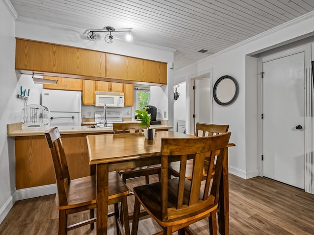 dining room with ornamental molding, dark wood-type flooring, and wooden ceiling