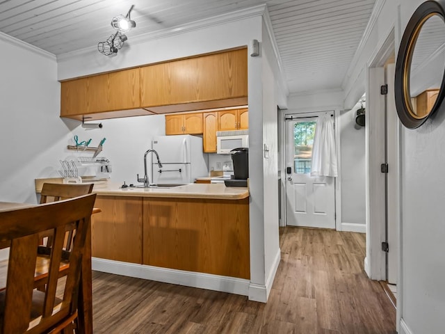 kitchen with white appliances, sink, dark hardwood / wood-style floors, ornamental molding, and kitchen peninsula