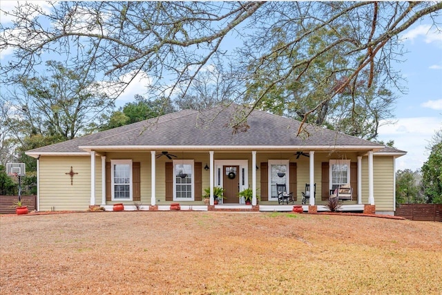 view of front of property featuring ceiling fan, a wall mounted air conditioner, a front yard, and covered porch