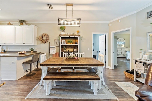 dining space featuring ornamental molding and dark hardwood / wood-style floors