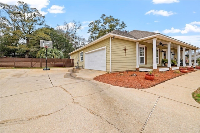 view of property exterior featuring a garage, ceiling fan, and covered porch