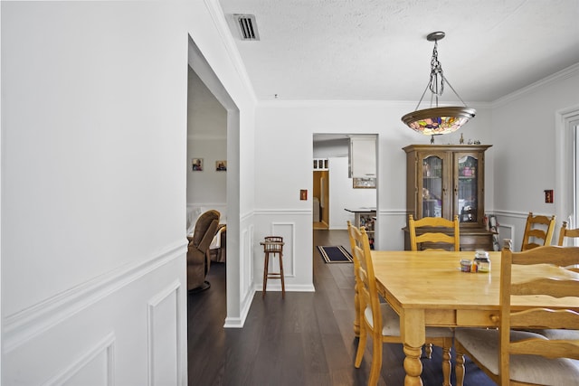 2025 Shadey Oaks Dr, Tallahassee, FL 32303 - dining space with dark wood-type flooring, crown molding, a wainscoted wall, a decorative wall, and a textured ceiling