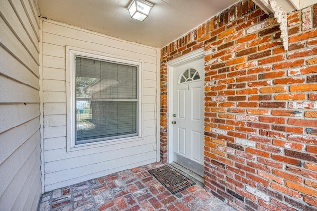 entrance to property featuring brick siding