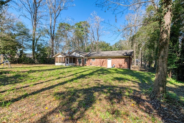 exterior space with a front lawn, fence, and brick siding