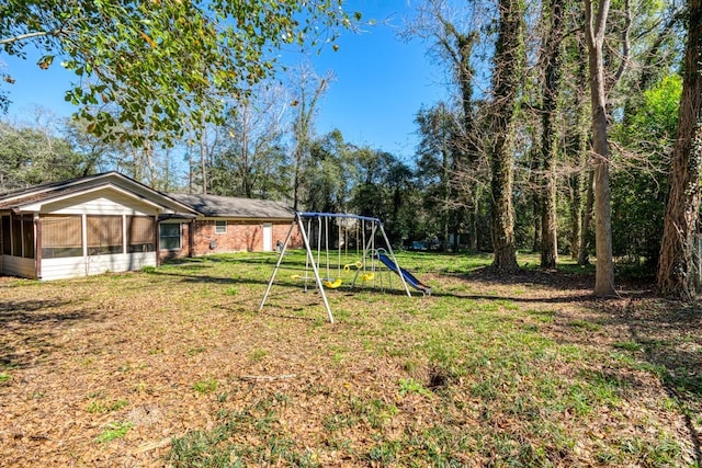 view of yard with a sunroom and a playground